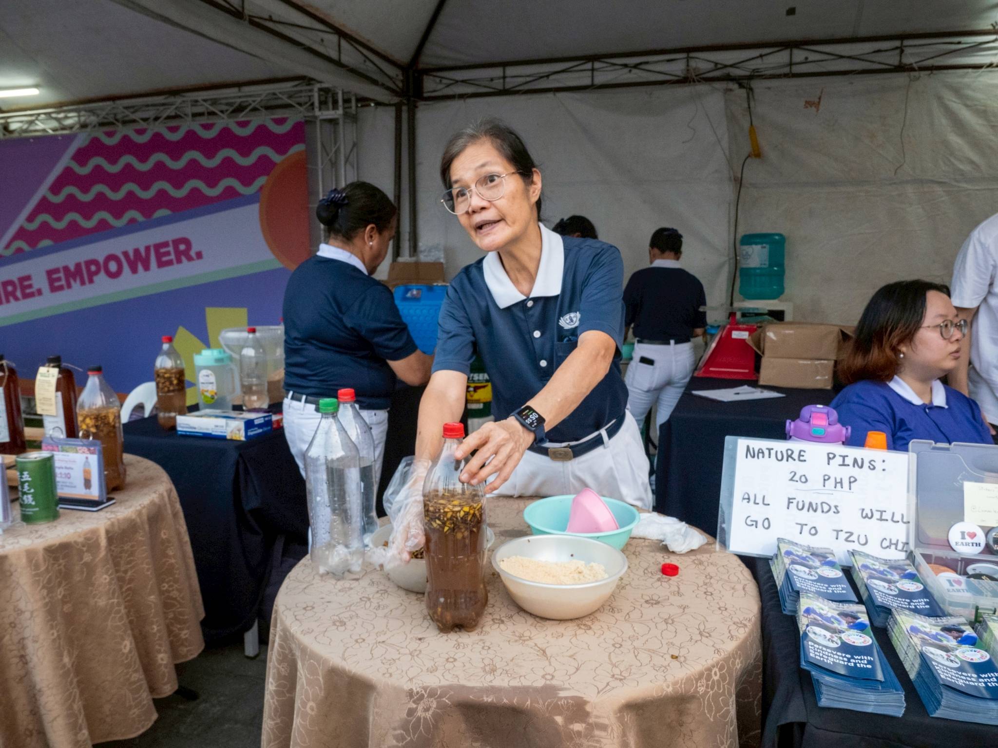 Tzu Chi volunteer Elvira Chua invites runners to try their hand at making eco-enzyme, a chemical-free all-purpose cleaner whose chief ingredient is fermented fruit and vegetable peels. 