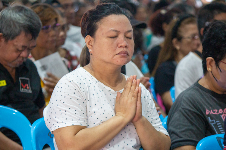 A beneficiary prays with a sincere heart.