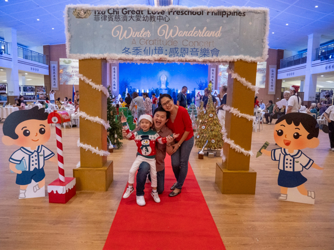 A family poses for a photo as they enter the venue for the “Winter Wonderland: A Thanksgiving Concert.”