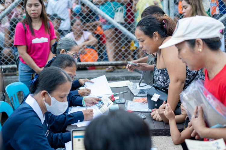 Tolerating the extreme heat, Tzu Chi volunteers collect the information of the residents on a masterlist before giving out two stubs: one for relief items and one for a 10-kilogram sack of rice.