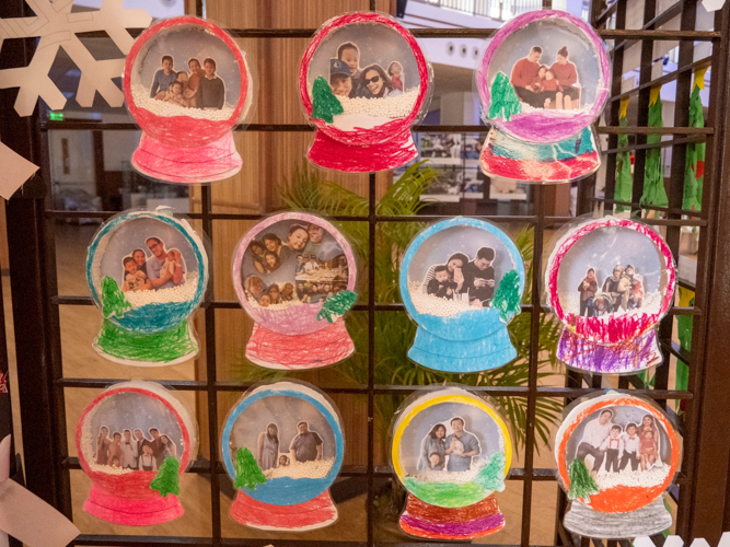 Made by the nursery and pre-kindergarten students, beautiful snow globes with family pictures adorn the event venue.