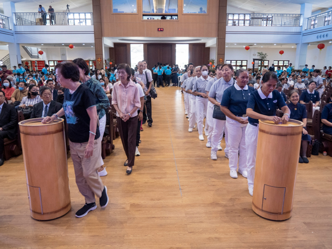 In a moving display of collective generosity, attendees contribute their donations to the bamboo banks, each coin representing their support to Tzu Chi’s mission of compassionate service.