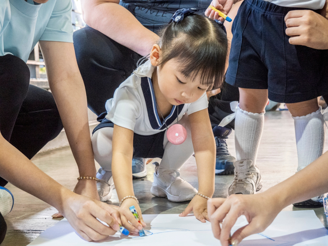 A student puts her best effort in drawing a dolphin for their banner.