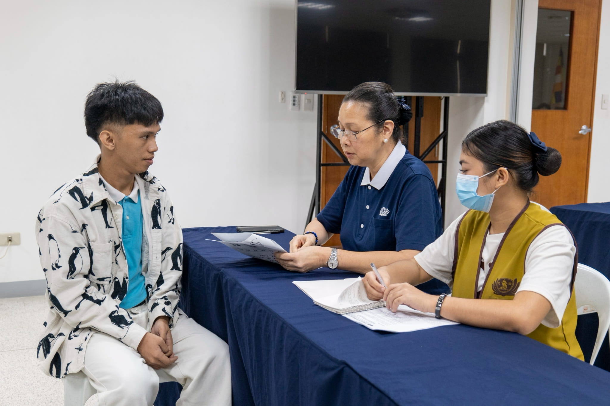 Nhorhabib Acraman (left) tells Tzu Chi volunteer Joy Gatdula (center) that he decided to stop studying when he received a call about his Tzu Chi scholarship application. Six years later, he is graduating cum laude from his Bachelor of Science in Industrial Education (major in Home Economics) from the Technological University of the Philippines.