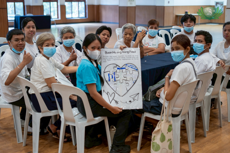 Beneficiaries form groups, and with the help of Tzu Chi scholars, fill up an illustration of a heart with things and experiences that make them happy.