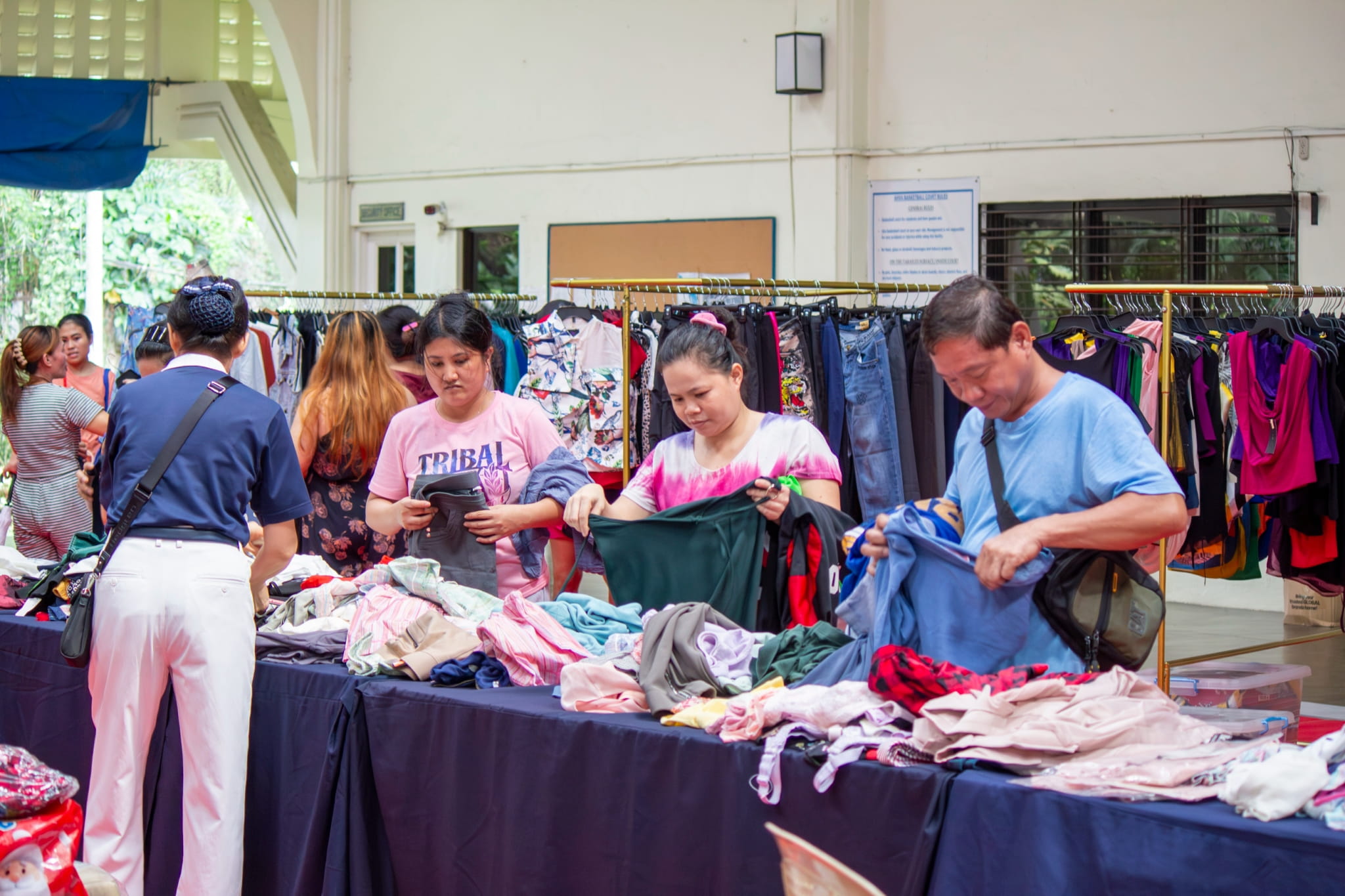 Shoppers browse a variety of items, from clothes and accessories to home essentials and toys. 