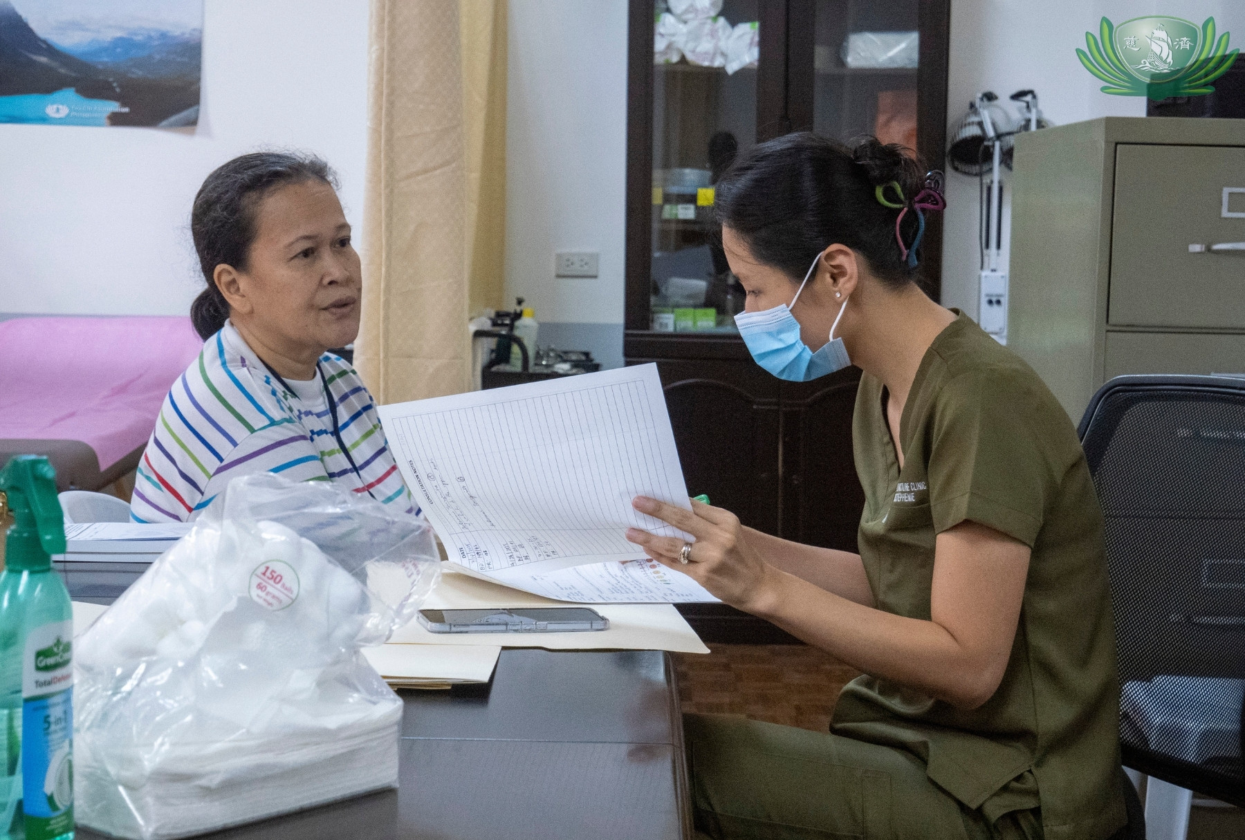 Maribeth Menge (left) explains her condition to Traditional Chinese Medicine (TCM) doctor Kristephenie Liang (right).