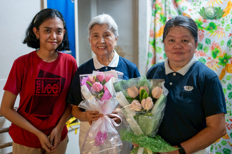 Lloyd’s sister Fatima Mañalac graduated cum laude from her course in elementary education at Tarlac State University. Tzu Chi Philippines’ first CEO Linda Chua and Tzu Chi volunteer Ruby Ang (center and right) hold up handmade tulips created and sold by Fatima.