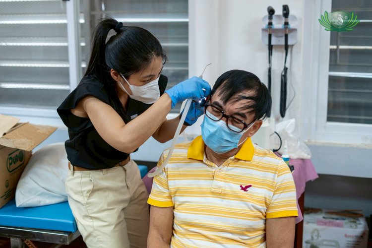 Dr. Joyce Rodvie Sagun uses an otoscope to check on the inner ear of Larry Velasquez, former Tzu Chi compliance officer and head of housekeeping.