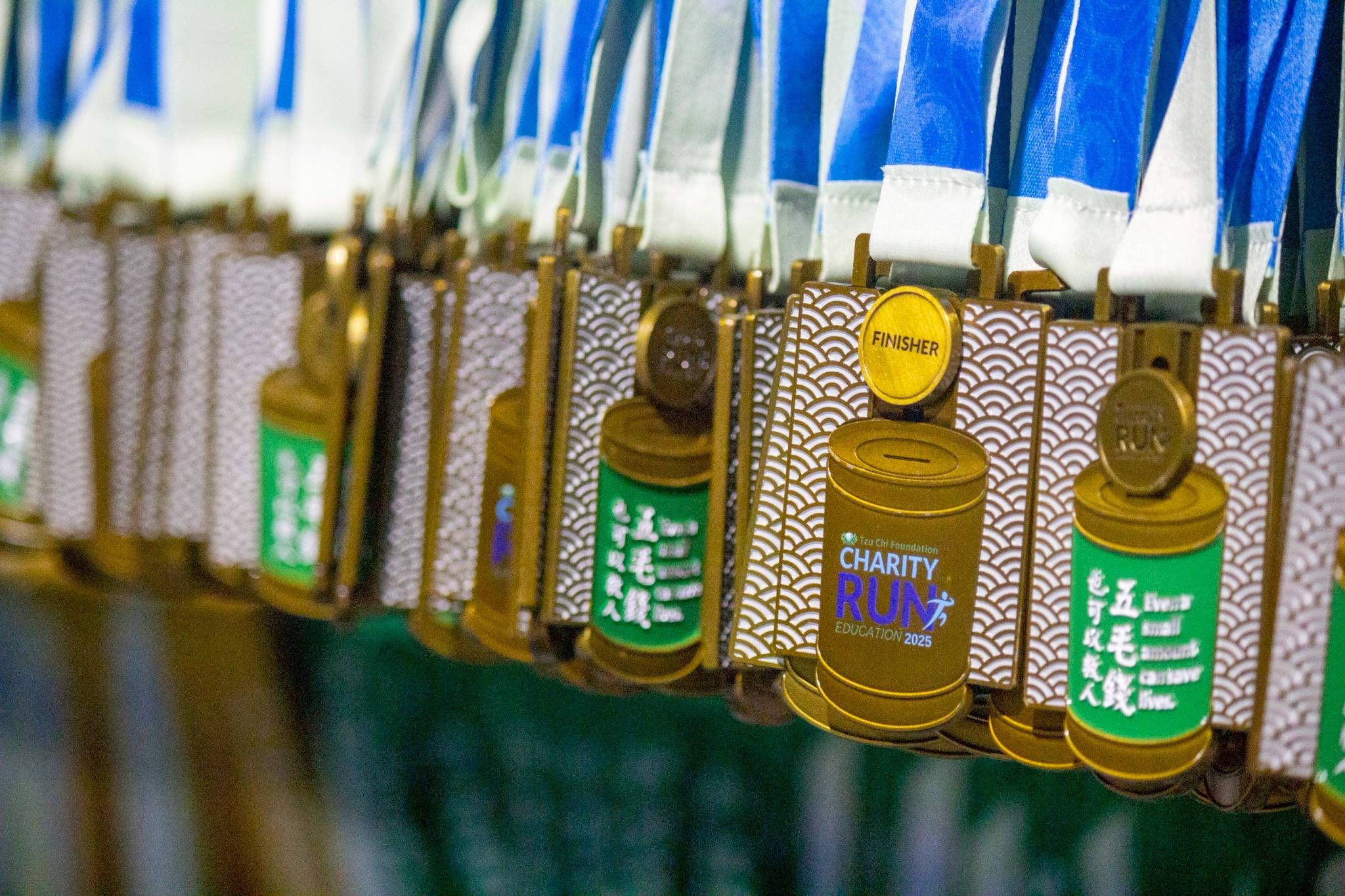 Tzu Chi’s coin can, which sprung from Dharma Master Cheng Yen’s earliest volunteers saving 50 cents a day to help the poor, inspired the charity run’s coveted finisher’s medals. 