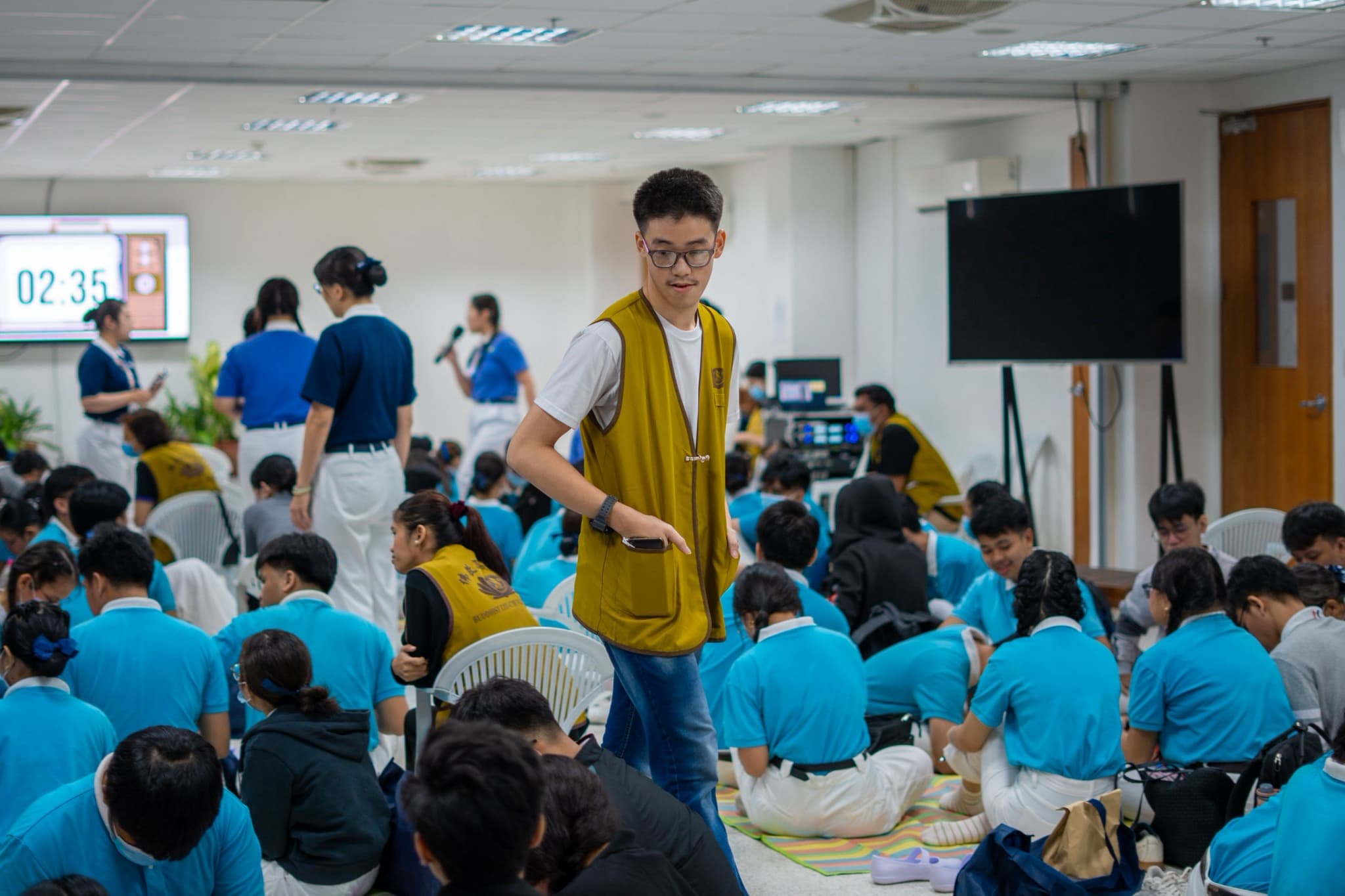 Manila-based Tzu Chi Youth member Rohann Fernandez (in Tzu Chi vest), who began volunteering last year, helps facilitate the group activity. 