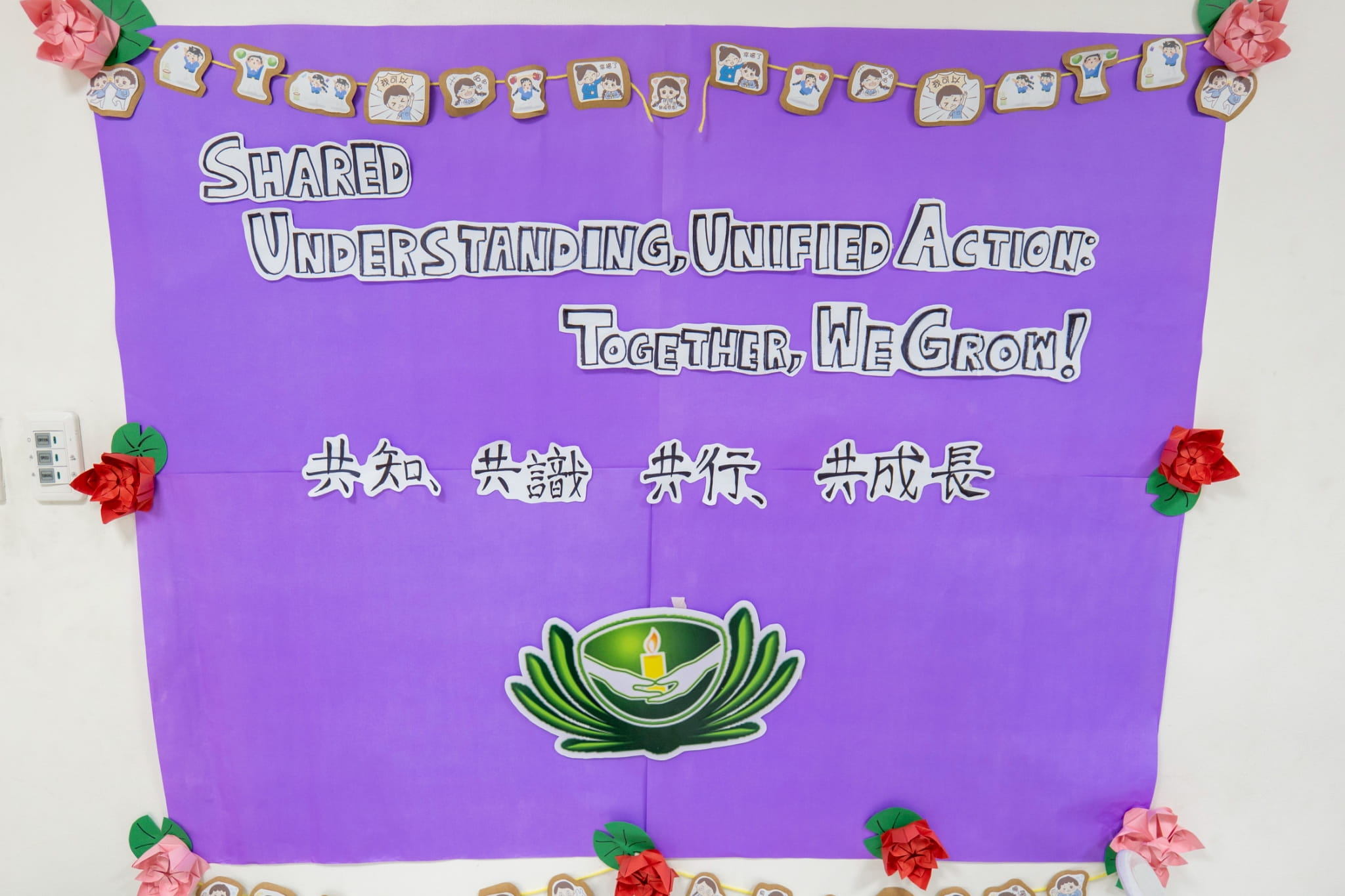 Organizers post the advancement camp’s theme on the wall.