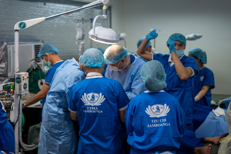 Volunteer surgeons and healthcare workers from different Tzu Chi chapters around the Philippines work together on a patient.