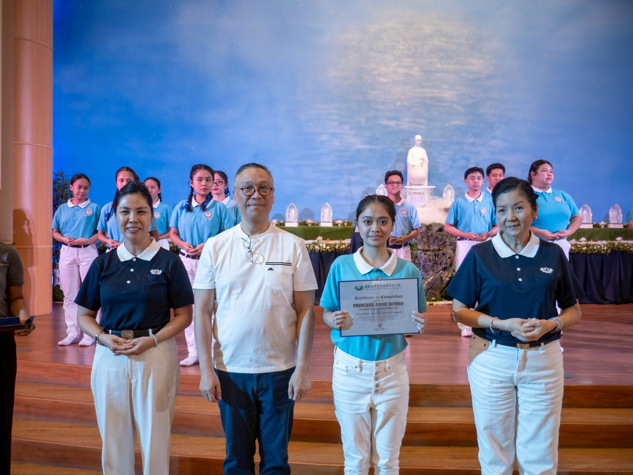 Regan Industrial Sales, Inc. CEO Regan Sy (second from left) participates in presenting scholars with their certificates. He is joined by Tzu Chi Pampanga volunteer Pansy Ho (left) and Rosa So, head volunteer for the educational and medical assistance programs (right).