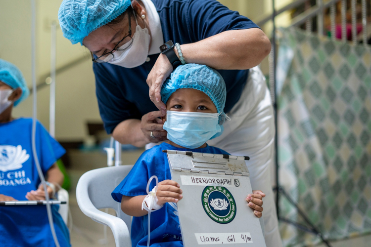 Four-year-old patient Gil Llames is being prepared for herniorrhaphy by a Tzu Chi volunteer. He is one of 51 medical mission patients to undergo the hernia operation.