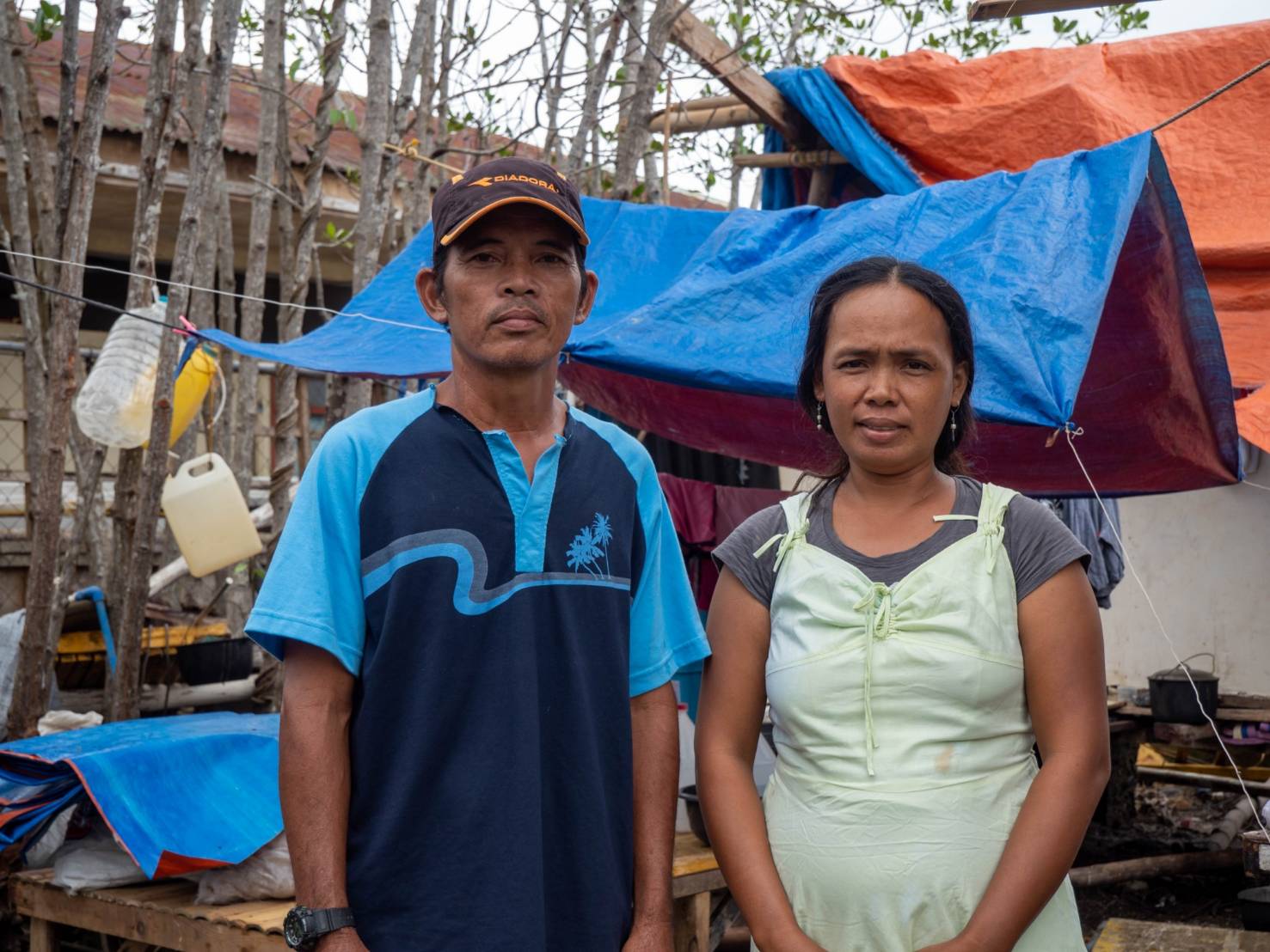 Nestor Browen (left), seen here with wife Jovelyn, lost his home, banca, and fishing net after Odette. The 49-year-old fisherman from Barangay Matabao now sells shells to earn money. 【Photo by Marella Saldonido】