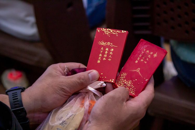 Tzu Chi Philippines CEO Henry Yuñez leads commissioners in the distribution of ampao containing commemorative coins from Dharma Master Cheng Yen.