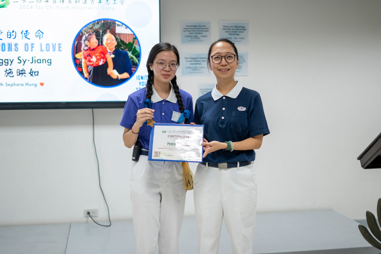 Tzu Chi Youth Jenny Chua (left) presents a certificate of appreciation to Tzu Chi Philippines Deputy CEO Peggy Sy-Jiang for her talk “Buddhism in Action.” 