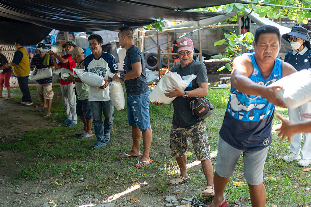 Practicing “bayanihan” or community spirit, Jose Abad Santos residents work together to unload sacks of rice from the Tzu Chi truck. 