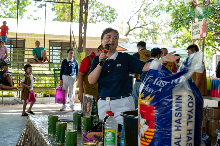 Tzu Chi volunteer Sharon Sy, who helped lead the team of volunteers, happily showed beneficiaries the different items they will receive.