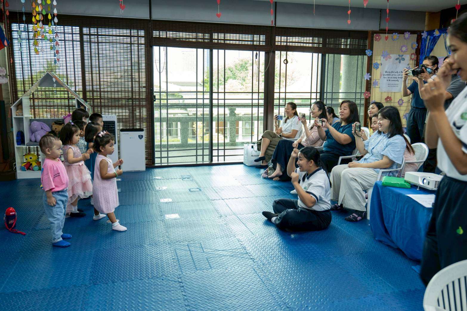 Moms grab their phones to take photos and record their children performing, making sure to capture every sweet memory of their little ones. 