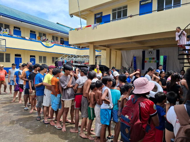 Storm victims line up as they receive hot meals prepared by Tzu Chi Bicol volunteers and JLo Big Heart Foundation at Rosario Evacuation Center.