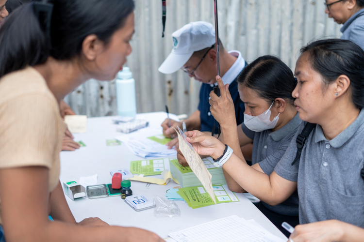 Ensuring everyone will receive help, a Tzu Chi volunteer and staff verify those affected residents whose names are not included on the list.