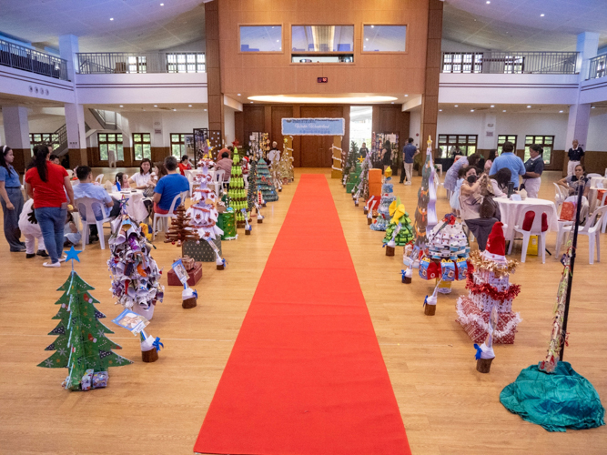 Students’ eco-friendly Christmas trees line the bright red carpet.