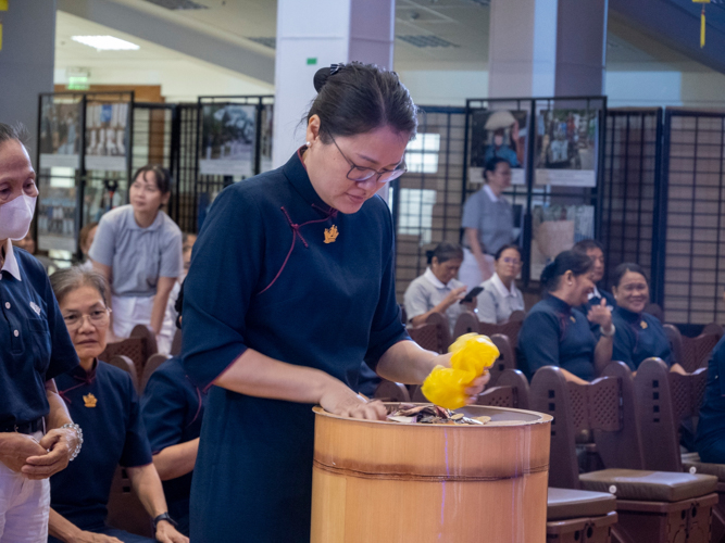 In a moving display of collective generosity, attendees contribute their donations to the bamboo banks, each coin representing their support to Tzu Chi’s mission of compassionate service.