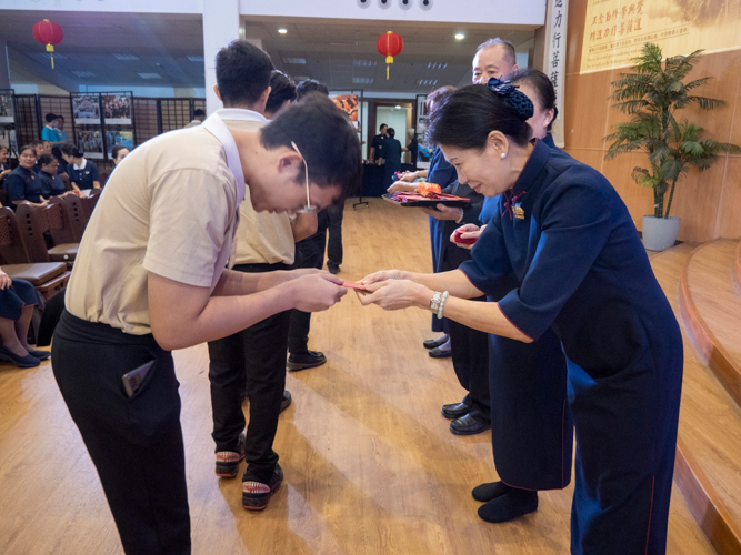 Tzu Chi Philippines Deputy CEO Woon Ng helps in the distribution of angpao, or a lucky red envelope.