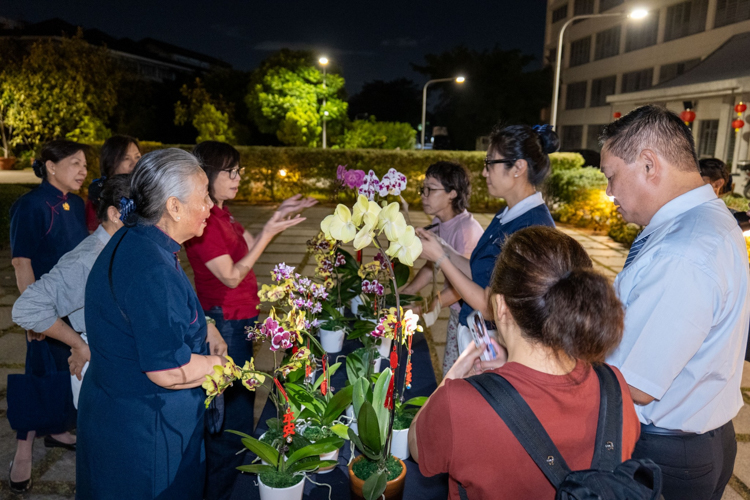 Visitors select orchids to offer at the Jing Si Abode.