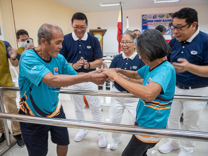 Prosthesis recipient Laurito Imfiel (left) happily dances with his wife (right).