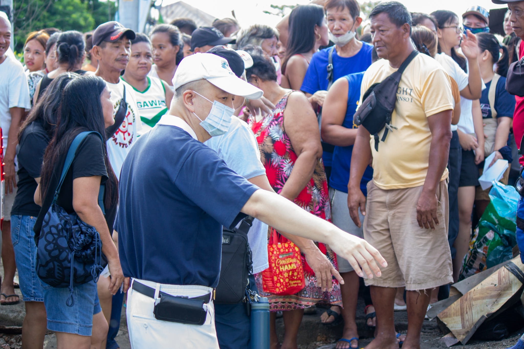 Tzu Chi volunteers lead in crowd control as beneficiaries wait eagerly.