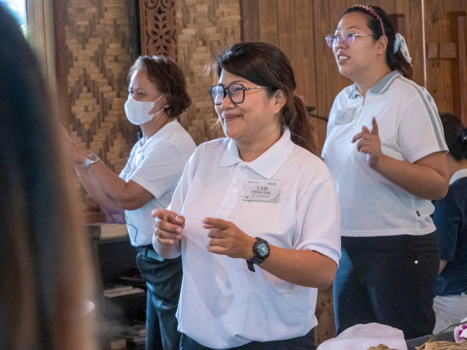 At the New Volunteers Camp, Annie Ong (center) participates in a sign language performance. 