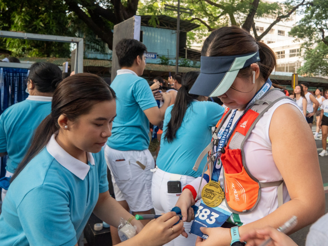 Scholars ensure that runners receive the right finisher’s medal.