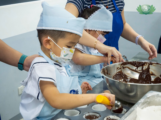 A learner proactively fills the cupcake trays with batter, looking forward to the delicious treat.