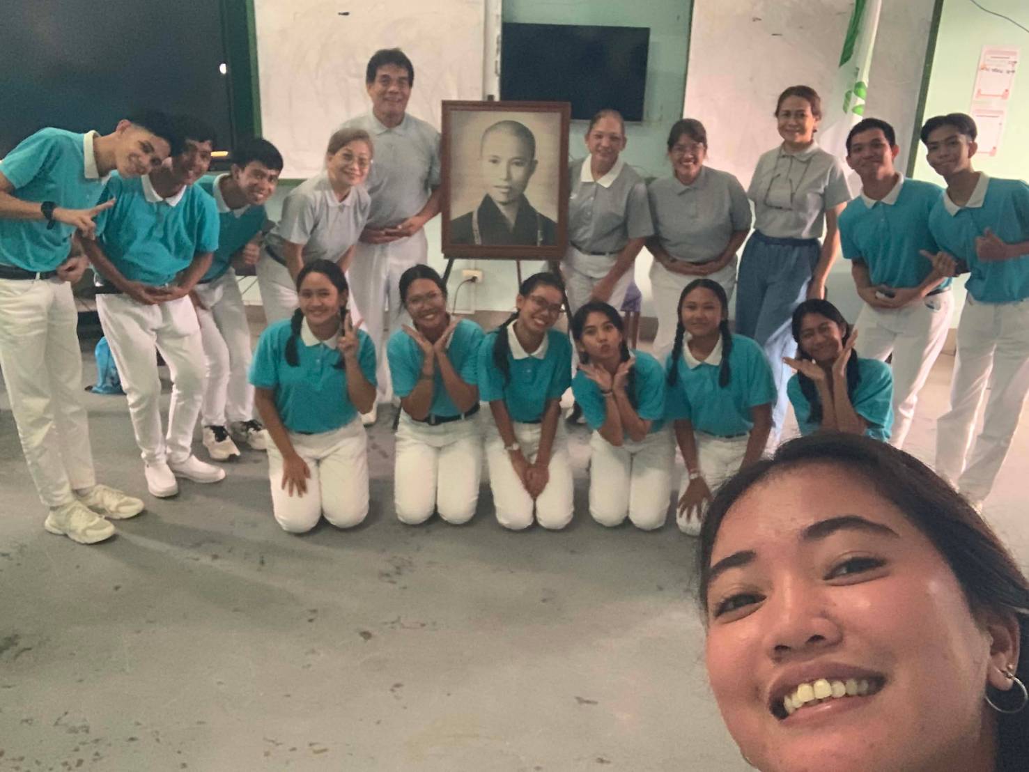 Tzu Chi Bicol scholars and volunteers gather for a group photo next to Master Cheng Yen’s portrait.