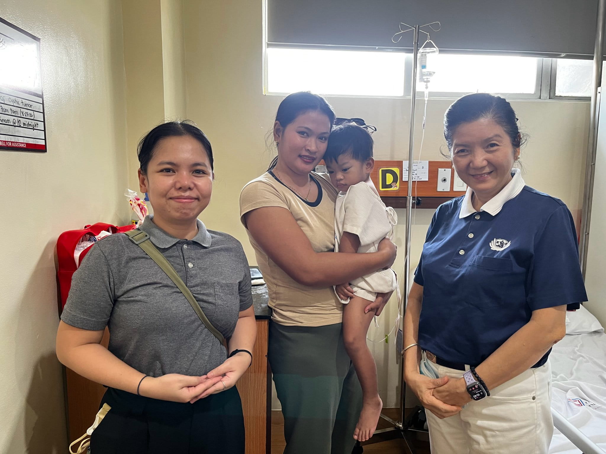 After the surgery, Tzu Chi Charity Department Social Welfare Officer Jackie Raper (left) and Tzu Chi Head Volunteer for the Educational and Medical Assistance Programs Rosa So ( right) visited Cyril Asher Aguila to check on his condition and recovery.