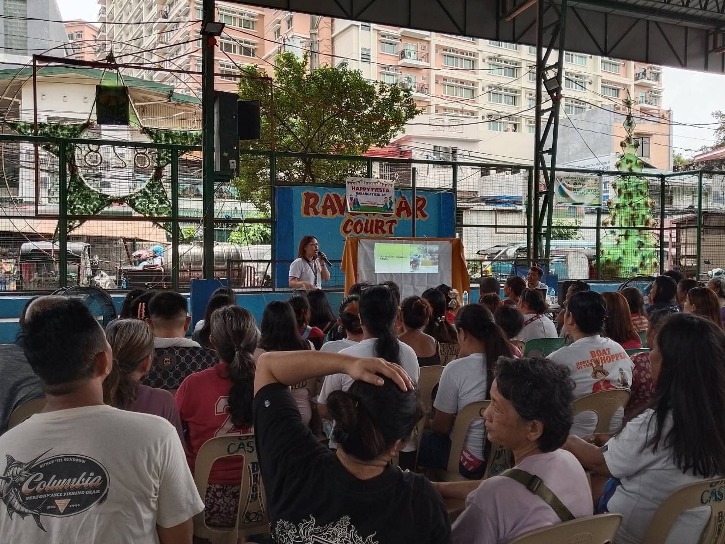 Comfortable with a mic, Daniella Macogue speaks to families in a Pantawid Pamilyang Pilipino Program.