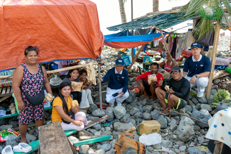Residents from Barangay Aplaya receive bread from Tzu Chi volunteers during an ocular survey to assess the impact on their community.