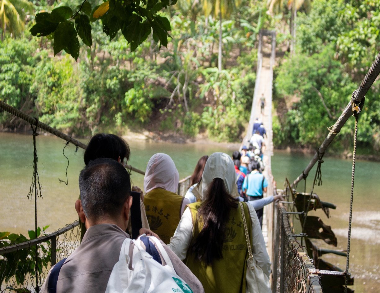 To get to Sitio Matol in Barangay Gupitan, Kapalong, Davao del Norte, for a banana seedling planting and shovel distribution program for Ata Manobo farmers, Tzu Chi Davao volunteers and scholars cross a precarious bridge / Photo courtesy of Tzu Chi Davao.
