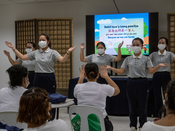 Graduates of Tzu Chi’s caregiver course in Taiwan teach scholars to sign “Isang Pamilya (One Family).”【Photo by Jeaneal Dando】 