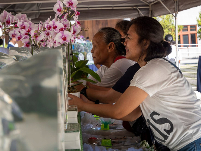 A parent of a Tzu Chi scholar happily places the orchids onto the table.
