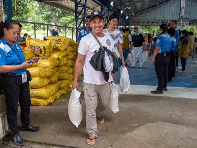 Beneficiaries are all smiles as they leave the distribution area with Tzu Chi’s relief goods. 