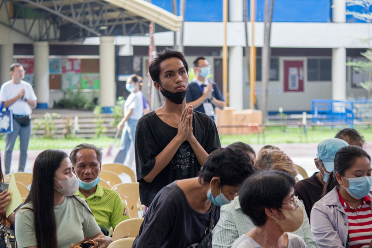 Moved by the uplifting messages of Tzu Chi volunteers, a beneficiary stands up and prays for his special intentions. 【Photo by Marella Saldonido】