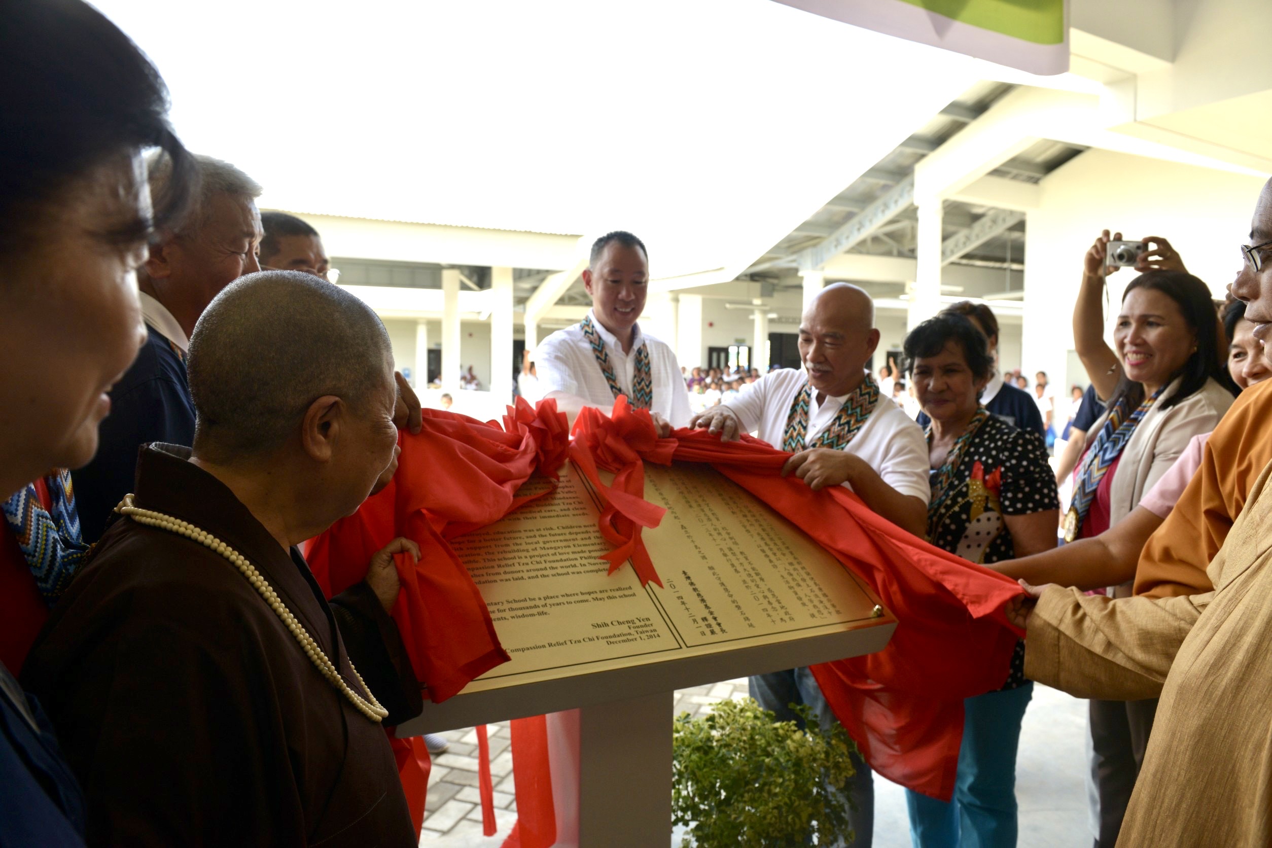 Special guests unveil a marker at Mangayon Elementary School with a message engraved in English and Chinese by Dharma Master Cheng Yen during the turnover ceremony of Mangayon Elementary School on December 1, 2014.