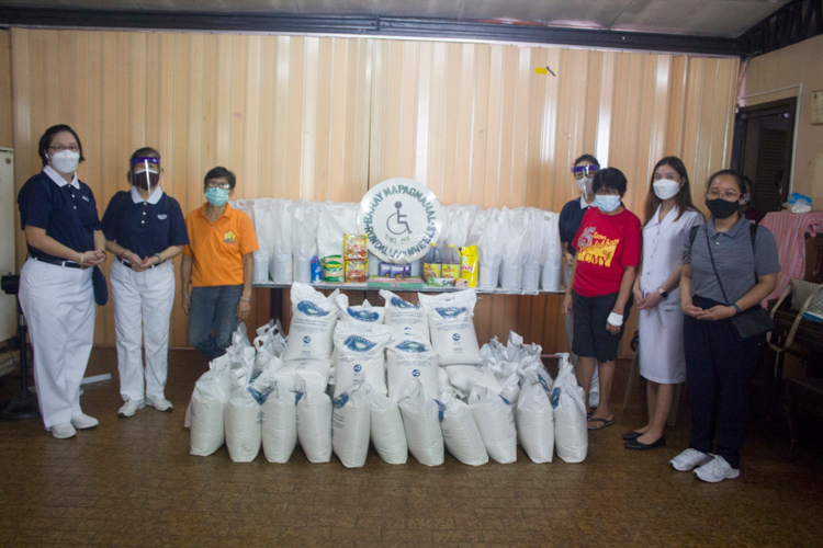 Tzu Chi volunteers and Bahay Mapagmahal staff pose with the donated sacks of rice and bags of grocery items. 【Photo by Matt Serrano】