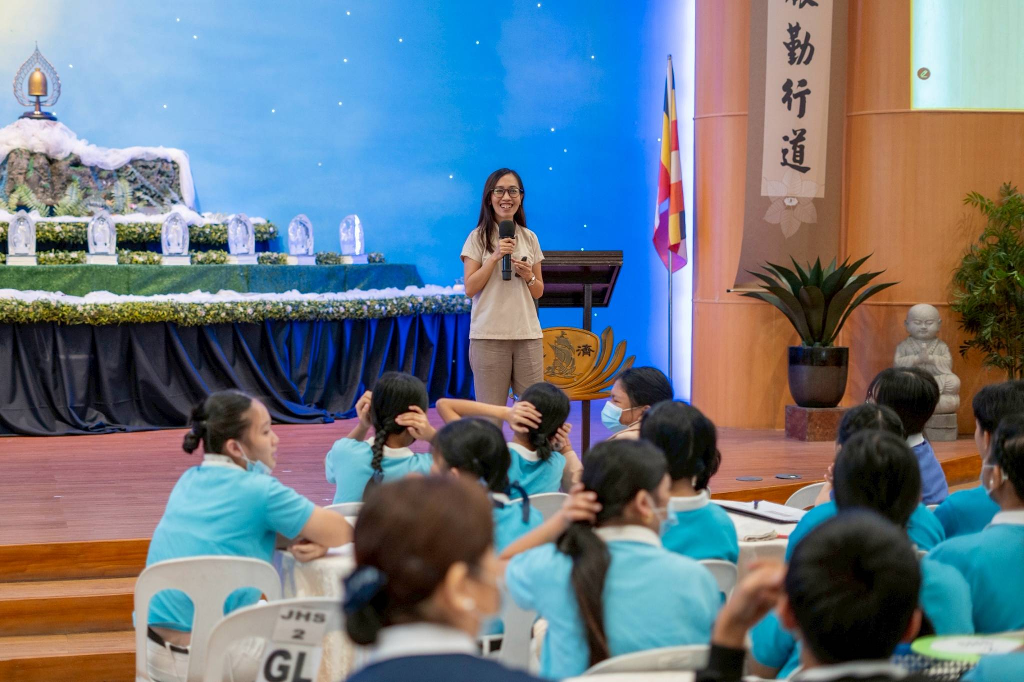 To stress the importance of hearing, audiologist Kristine Layson asks the audience to cup their ears with their hands and whisper what they had for breakfast to their seatmate. 