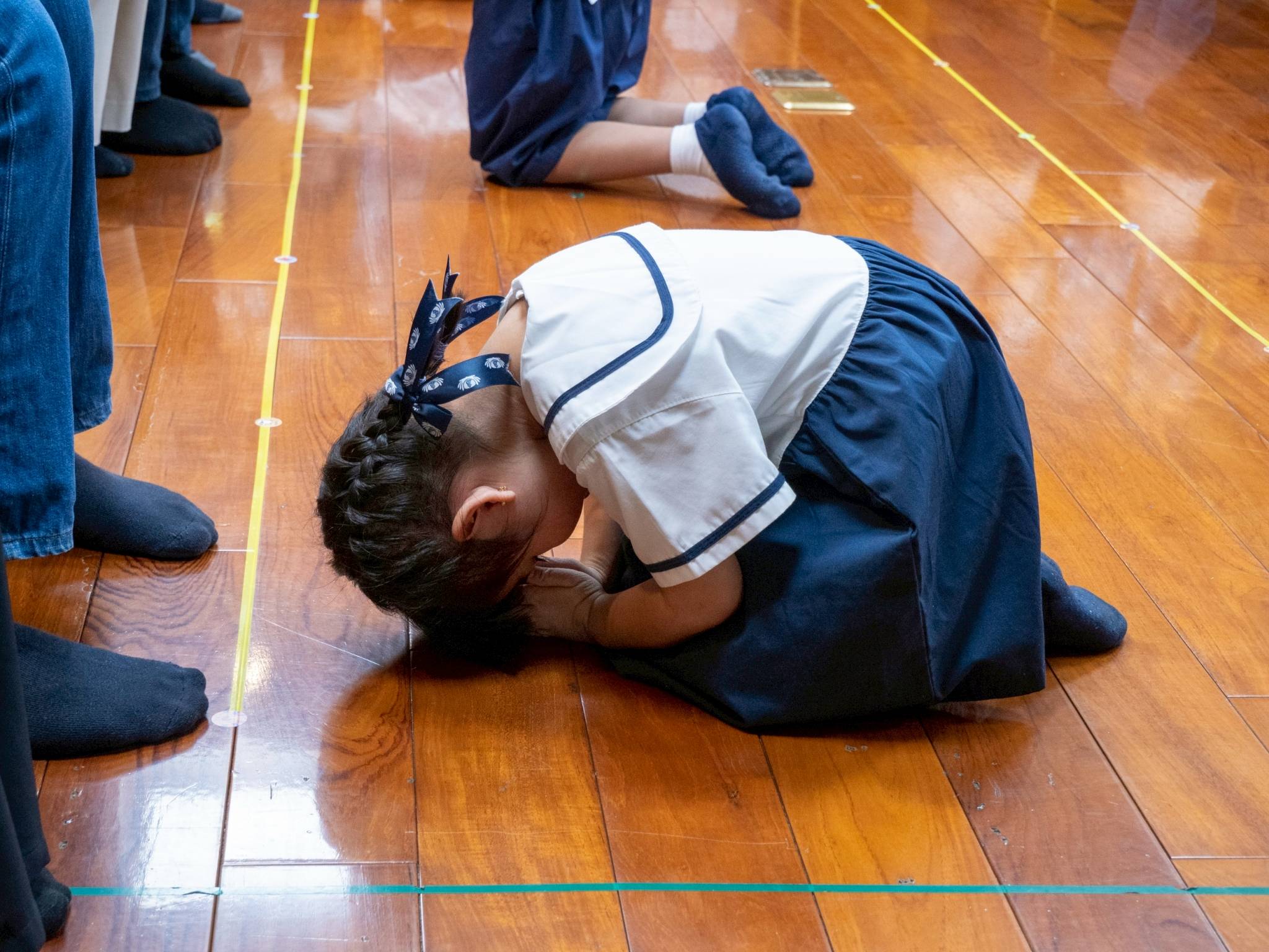 In a humble gesture, the students bowed and knelt before their parents to express their gratitude.