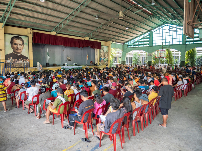 Beneficiaries learn about the history of Tzu Chi from a Tzu Chi staff at the Don Bosco Youth Center in Tondo, Manila.